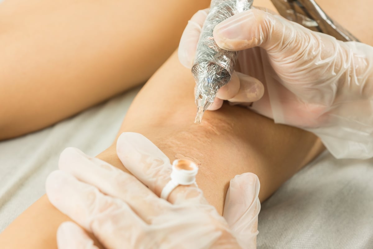 Close view of precise restorative tattooing work on skin